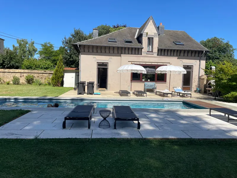 Sun loungers next to the heated pool in front of the poolhouse