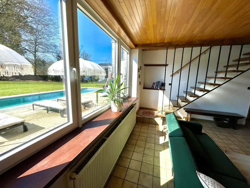 South-facing living room with large windows looking out on the pool