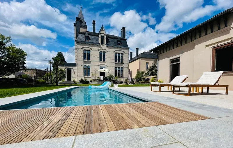 Wooden pool deck with the Art Nouveau Villa O in the background